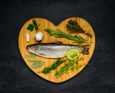 Bild-Nr: 11830411 Roher Fisch auf einem Herz Kochbrett mit Zutaten Erstellt von: xfotostudio