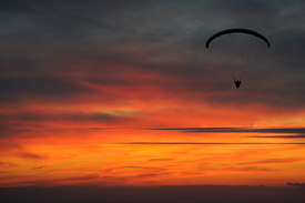 Gleitschirmfliegen in den Sonnenuntergang/9436342