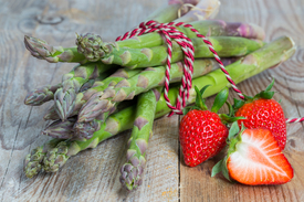 Grüner Spargel mit Erdbeeren auf Holz/11632397